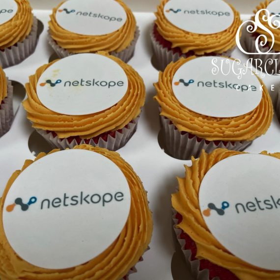 Red velvet and vanilla buttercream cupcakes topped with the company logo